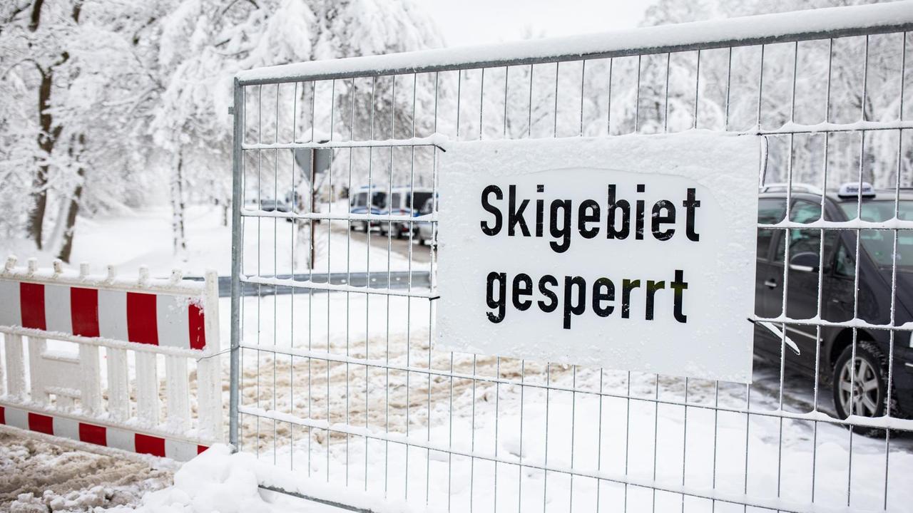 Wintersportorte im Sauerland und in der Eifel sind abgesperrt, um Touristen während des Corona-Lockdowns fernzuhalten. Vor einem Parkplatz steht ein Metallgitter mit der Aufschrift "Skigebiet gesperrt".
