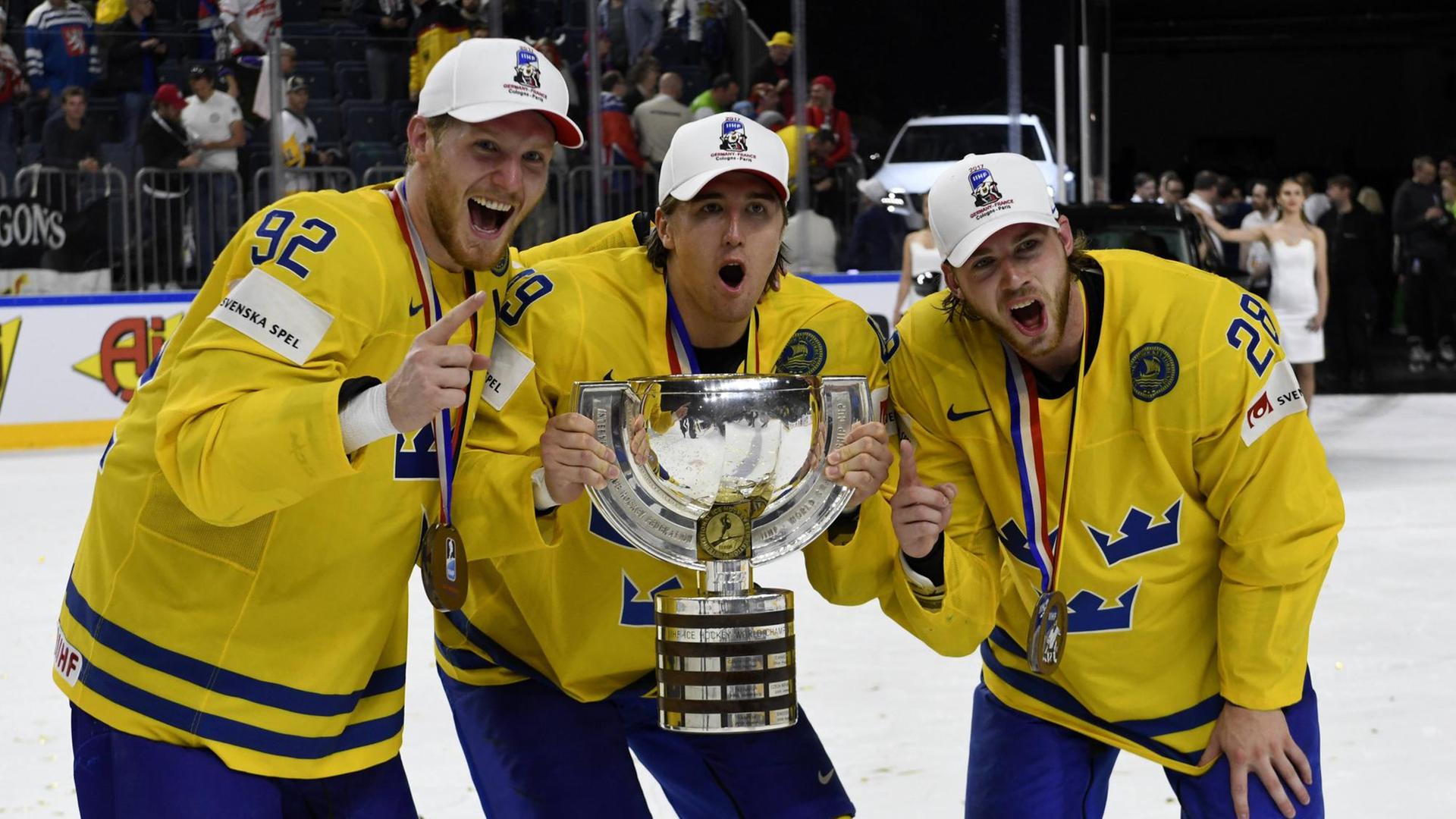 Drei schwedische Eishockey-Spieler halten den Weltmeisterschafts-Pokal.