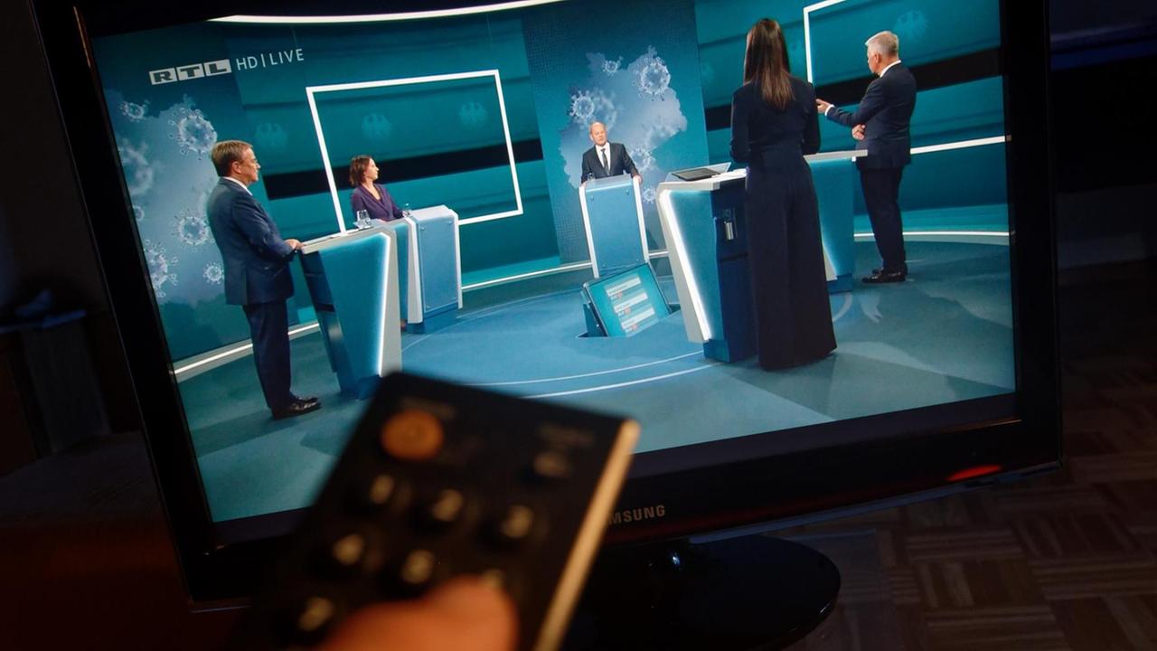 Auf einem Fernseher in einem Wohnzimmer ist "Das Triell" im Fernsehprogramm RTL zu sehen