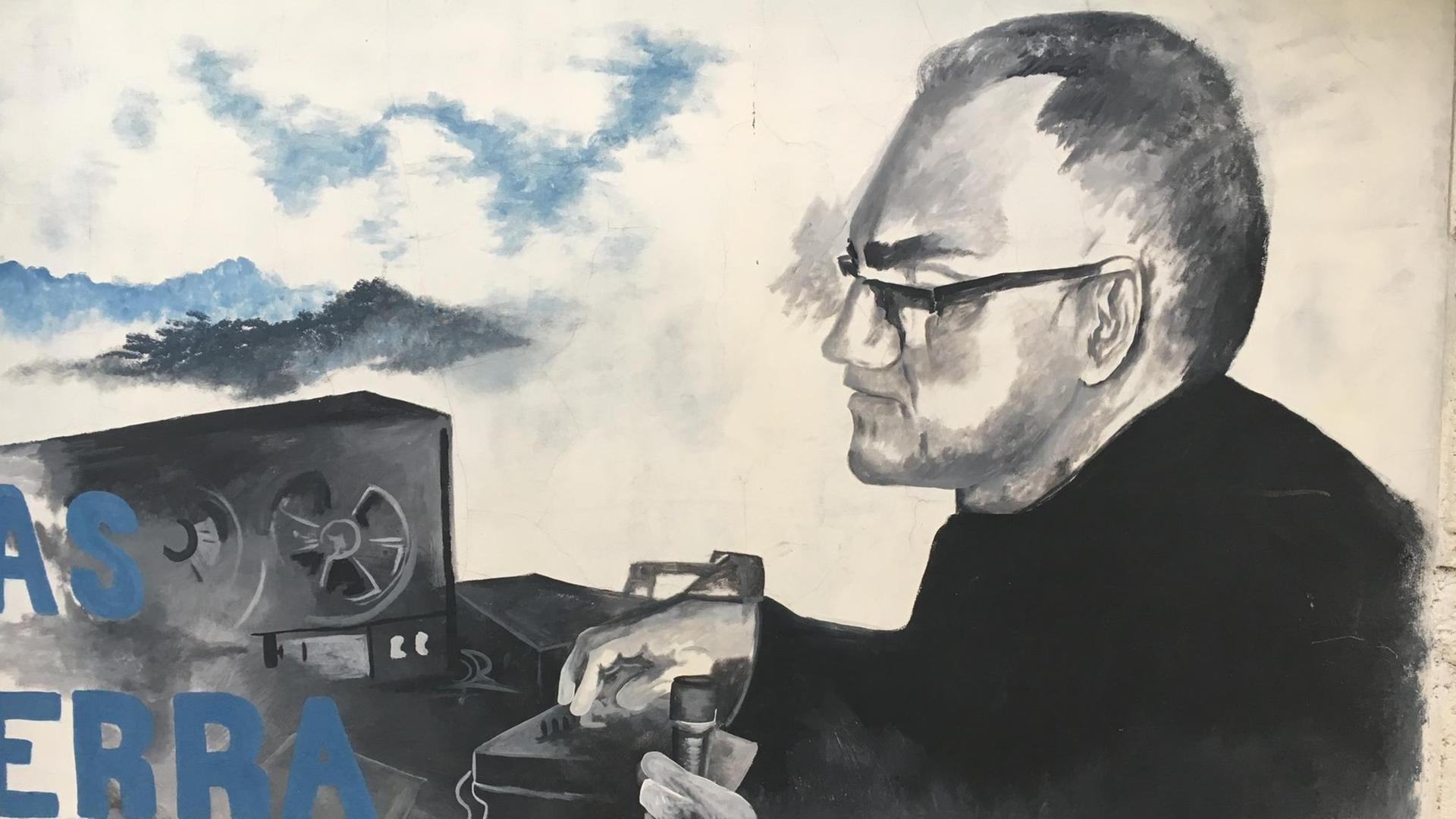 Ein Graffiti zeigt Oscar Romeros vor einem Radio.