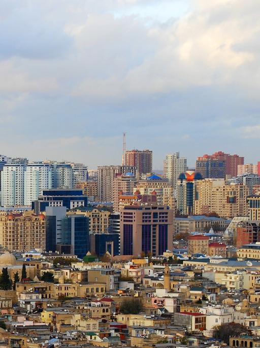 Die Altstadt der aserbaidschanischen Hauptstadt Baku mit Minaretten liegt vor dichtbebauten neuen Hochhäusern.