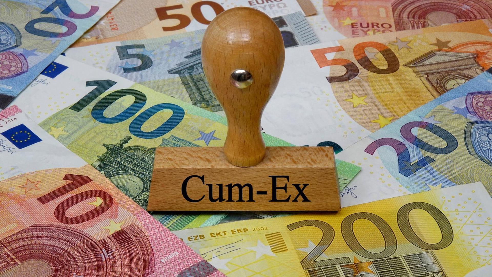 Stempel Cum-Ex, dahinter sind mehrere Euro-Geldscheine zu sehen.
