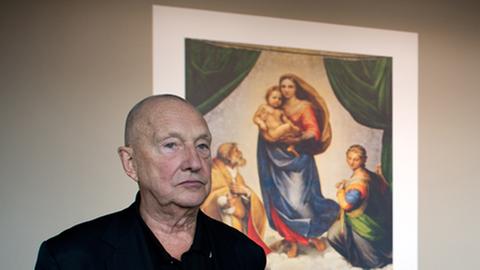 Der Maler und Bildhauer Georg Baselitz vor einer Reproduktion des Gemäldes "Sixtinische Madonna" von Raffael.