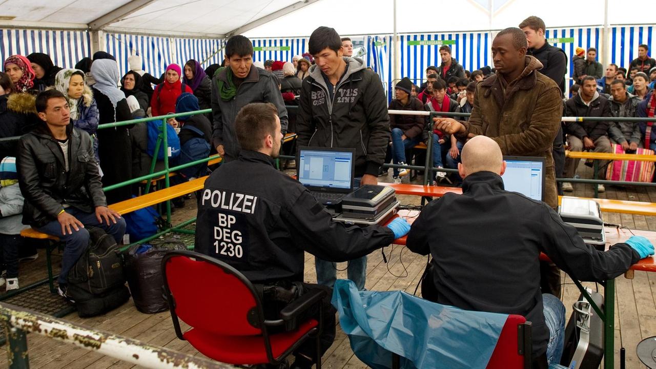 Flüchtlinge warten am 2. November 2015 in Passau (Bayern) am Bahnhof in einem Versorgungszelt auf ihre Registrierung.