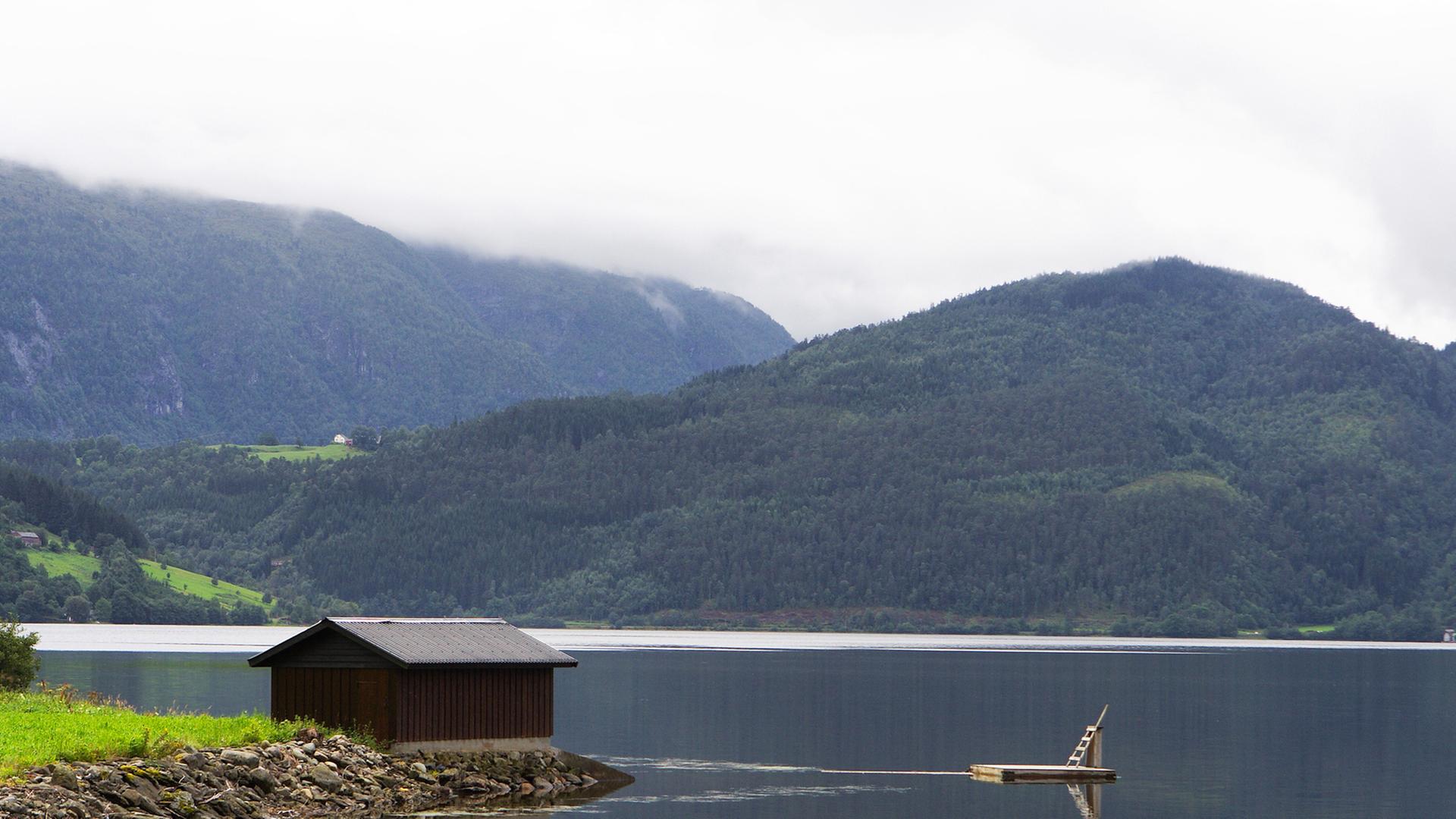 Blick auf eine einsame Hütte an einem See. 