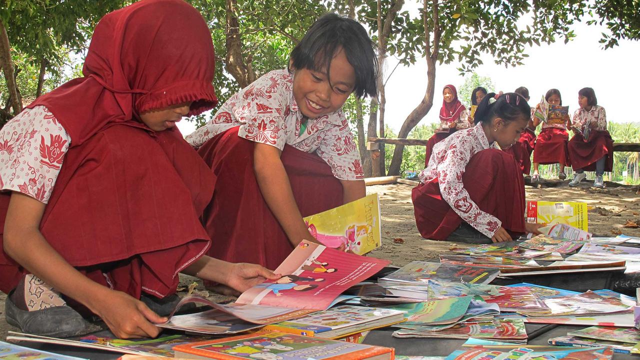 Endlich mal etwas anderes als Schulbücher - Freude auf dem Schulhof im Dorf Gonda in West-Sulawesi.