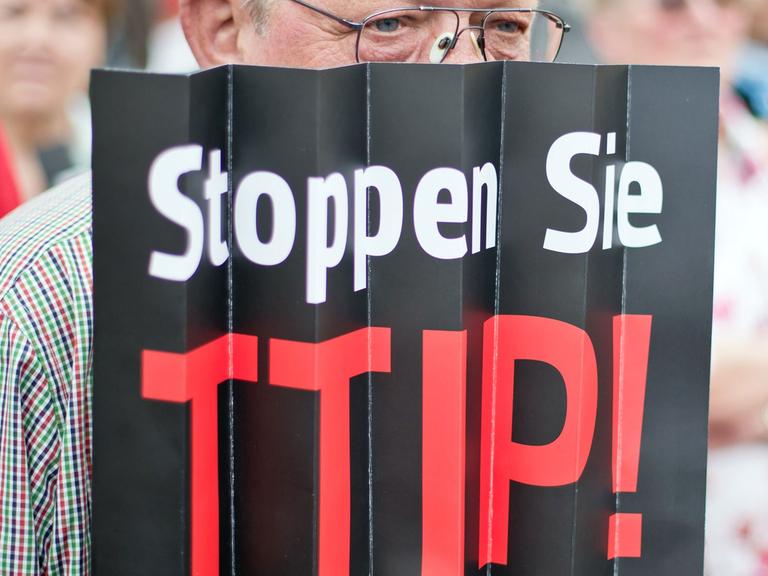 Ein Zuhörer einer Europawahlkampfveranstaltung der SPD protestiert in Nürnberg (Bayern) mit einem Plakat mit der Aufschrift "Stoppen Sie TTIP" gegen das geplante EU-US-Freihandelsabkommen TTIP.