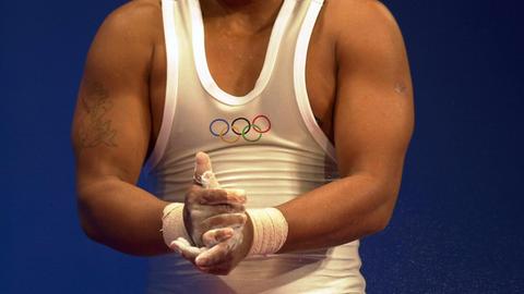 Oberkörper eines Gewichthebers, der seine Hände einreibt (Symbolbild)