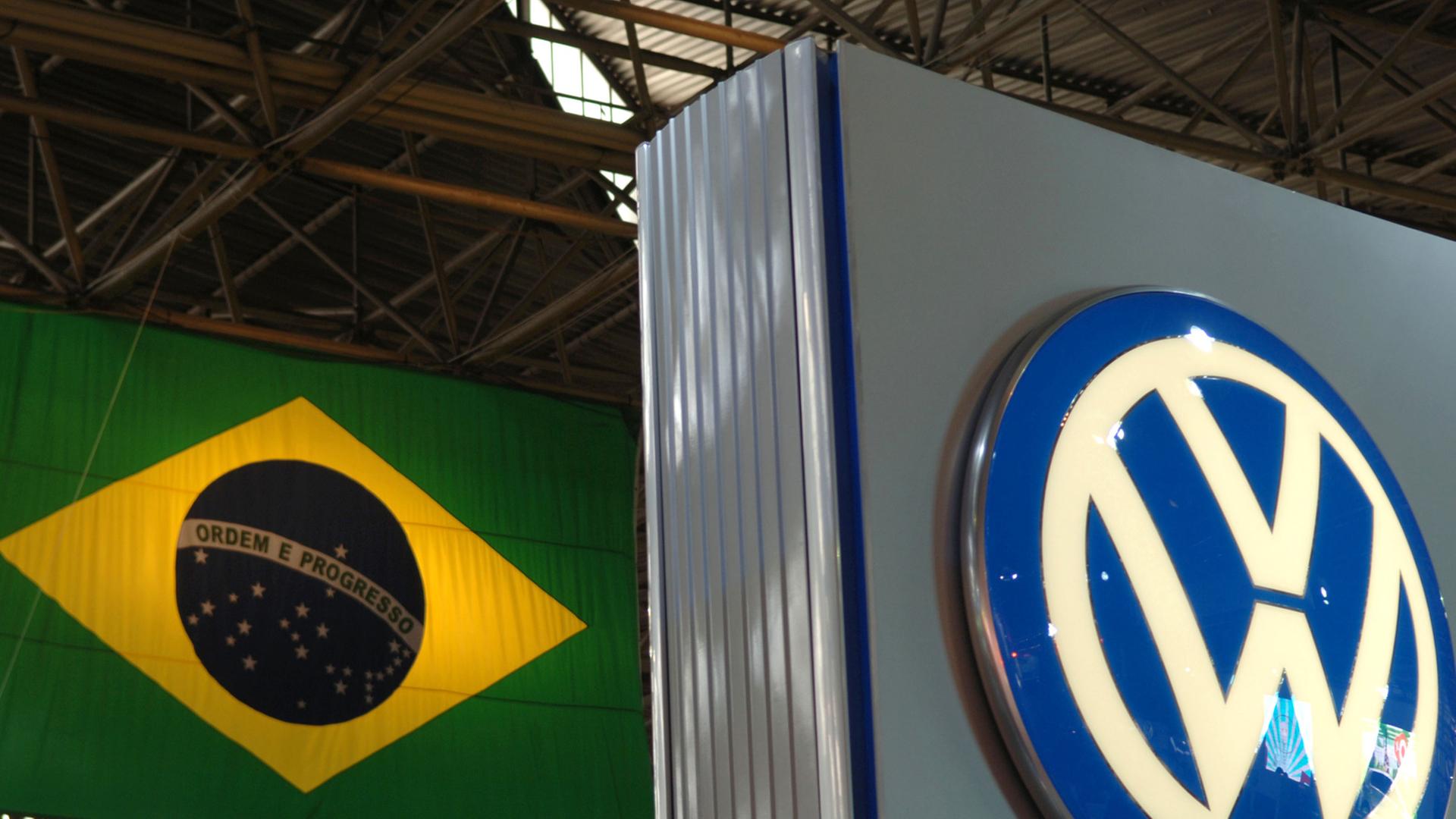 Das Logo von Volkswagen vor der Flagge von Brasilien