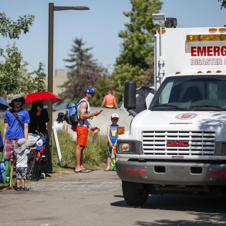 Kanada, Calgary: Ein Rettungswagen der Heilsarmee dient als Kühlstation, während die Menschen Schlange stehen, um in einen Wasserpark zu gelangen.