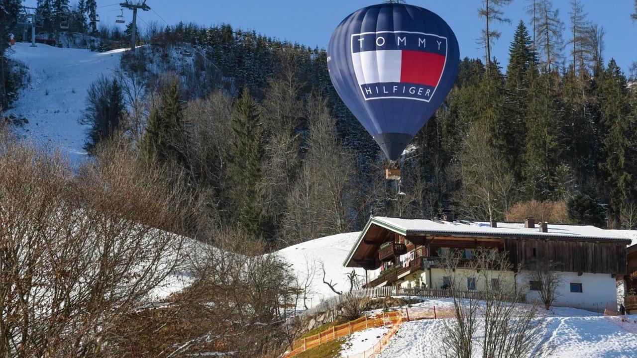Ein Heißluftballon mit dem Logo der Marke "Tommy Hilfiger" schwebt über dem Hahnenkamm in Kitzbühel.