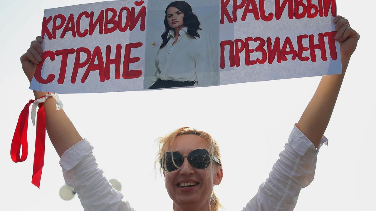 Eine Frau hält ein Schild mit einem Foto der ehemaligen Präsidentschaftskandidatin Swetlana Tichanowskaja und einer Botschaft mit der Aufschrift "Eine schöne Präsidentin für ein schönes Land" während eines Protests von Oppositionsanhängern auf dem Komarowskij-Markt in Minsk hoch.