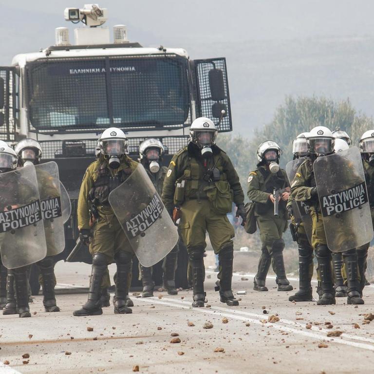 Griechenland, Lesbos: Bewaffnete Polizisten stehen auf einer Straße. 