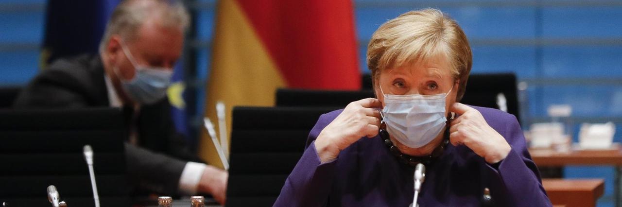 Bundeskanzlerin Angela Merkel nimmt ihre Gesichtsmaske ab, als sie zur wöchentlichen Kabinettssitzung der Bundesregierung im Kanzleramt eintrifft