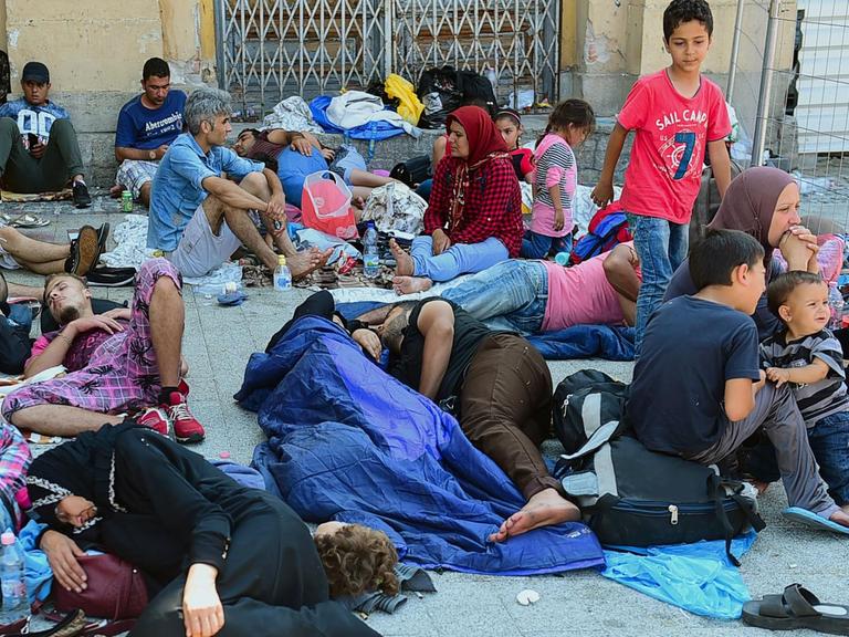 Erschöpfte Flüchtlinge sitzen und liegen vor dem Ostbahnhof in Budapest.