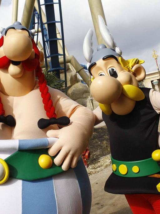 Die Figuren Obelix und Asterix vor dem Eingang der Achterbahn Oziris - im Vergnügungspark Parc Asterix bei Paris, April 2012.