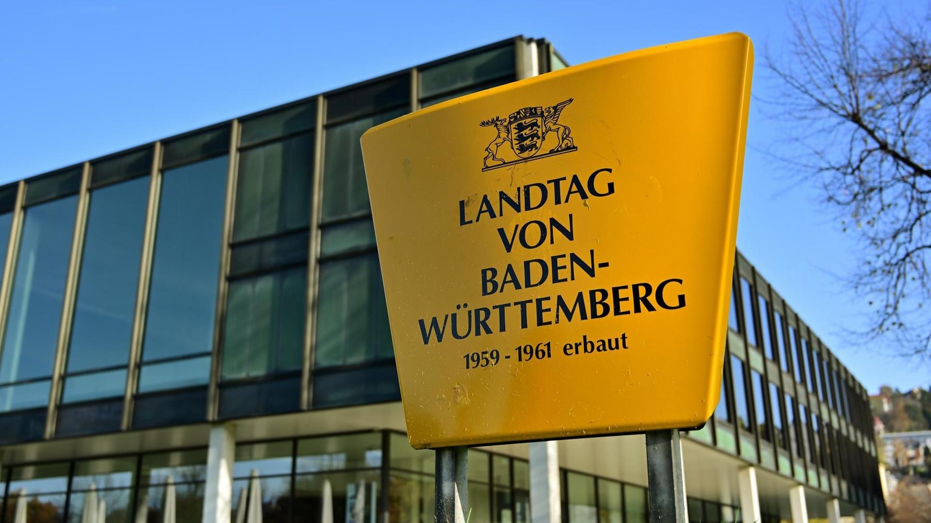 Außenaufnahme des Landtags von Baden-Württemberg. Im Vordergrund ein Schild mit der Aufschrift: Landtag von Baden-Württemberg. 1959-1961 erbaut.