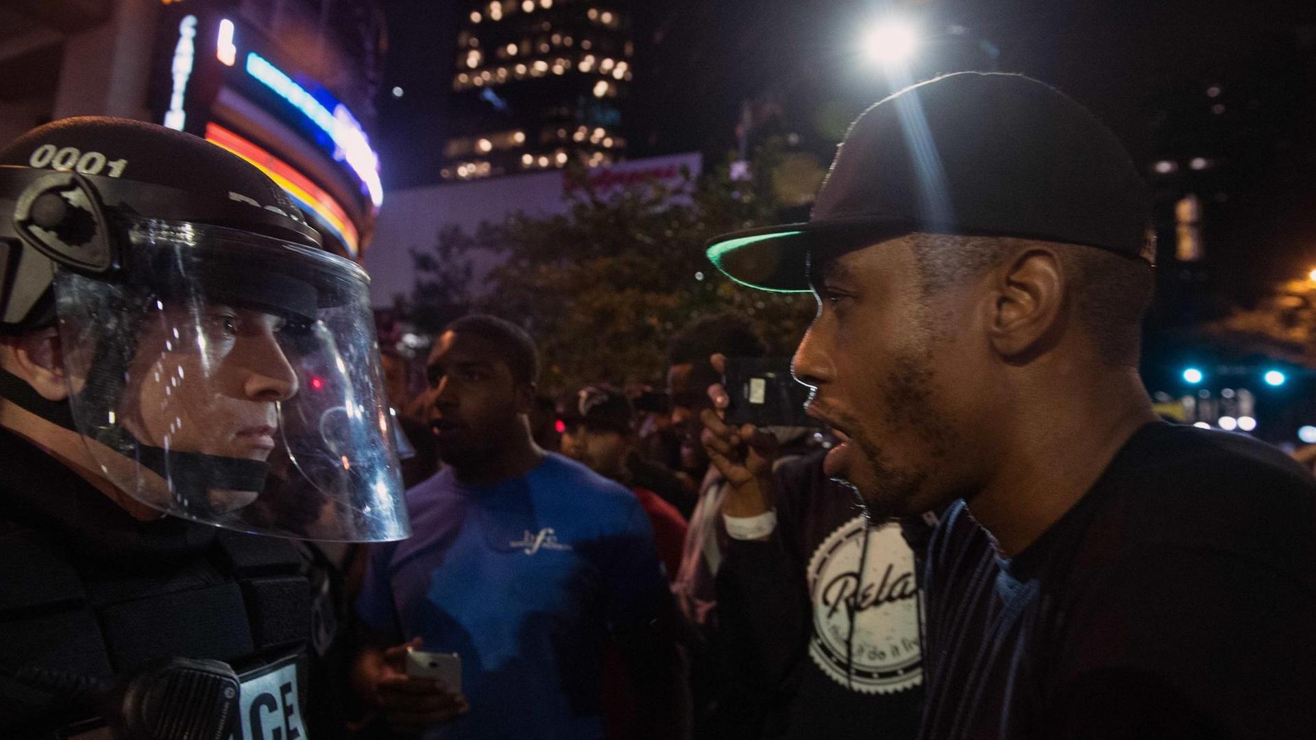 Ein Demonstrant und ein Polizist stehen sich in der US-Stadt Charlotte gegenüber
