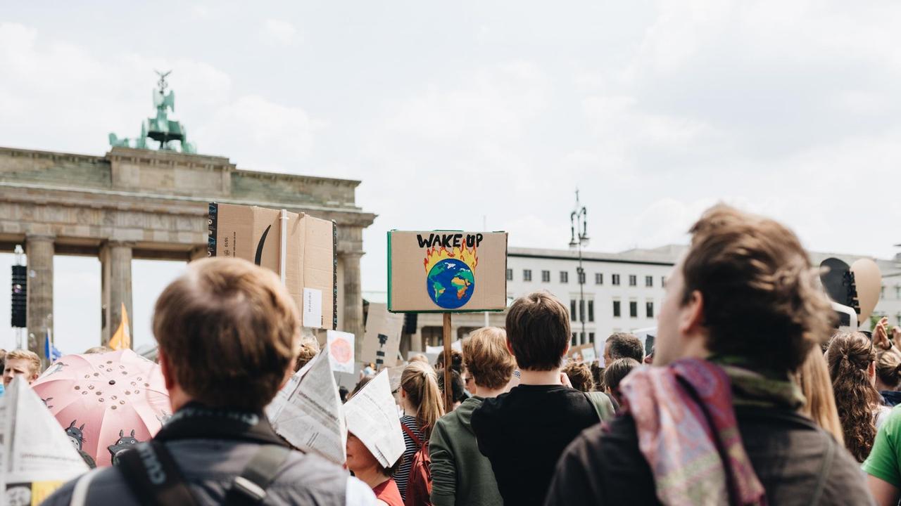 Junge Menschen protestieren am Brandenburger Tor in Berlin gegen die Erderwärmung, auf einem Schild steht "Wake up / Wacht auf".