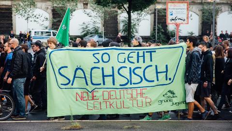 Asylbefürworter ziehen am 27.07.2015 in Dresden (Sachsen) mit einem Banner "So geht sächsisch - neue deutsche Leitkultur" durch die Innenstadt von Dresden.