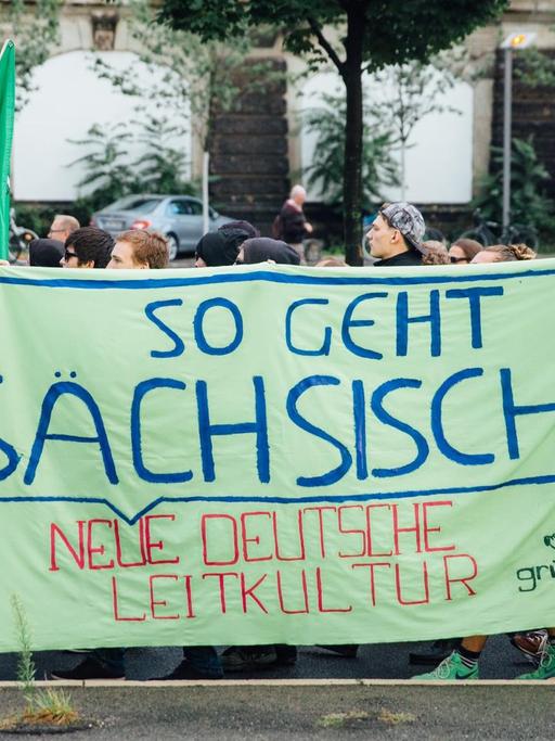 Asylbefürworter ziehen am 27.07.2015 in Dresden (Sachsen) mit einem Banner "So geht sächsisch - neue deutsche Leitkultur" durch die Innenstadt von Dresden.