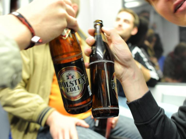 Zwei Jugendliche stoßen in Hamburg in einer S-Bahn mit Bier an.