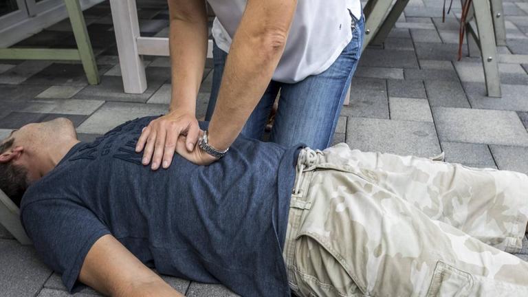 Symbolfoto: Wiederbelebung mit einer Herz-Druck-Massage nach Kreislauf- Stillstand durch Stromschlag beim Elektronik Basteln, gestellte Szene.