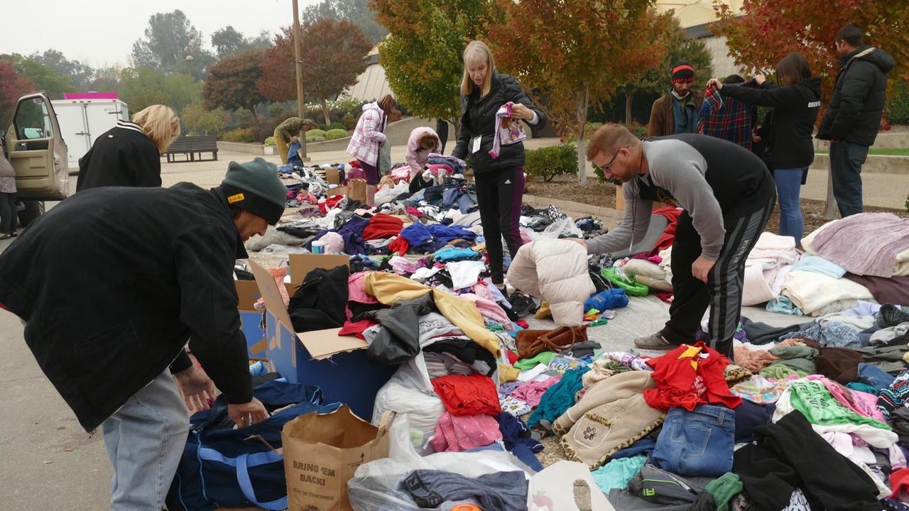 Vor einer Notunterkunft in Chico, Kalifornien, USA, suchen sich von den Waldbränden Betroffene Kleiderspenden aus.