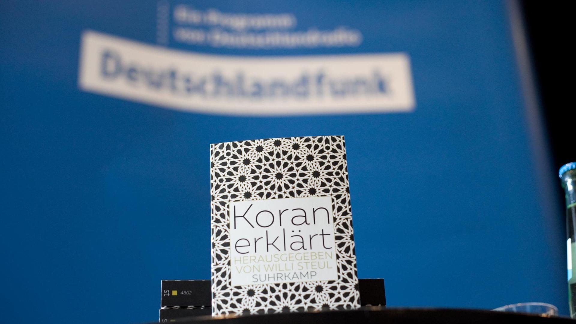 Buchvorstellung "Koran erklärt". Im Hintergrund ein Logo des Deutschlandfunks