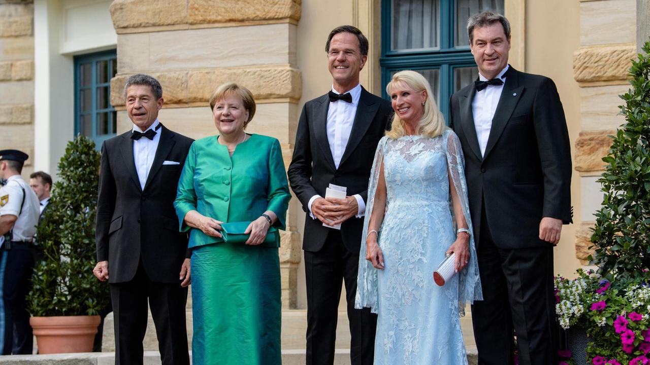 25.07.2018, Bayern, Bayreuth: Joachim Sauer (l-r) und seine Frau, Bundeskanzlerin Angela Merkel (CDU), stehen mit Marc Rutte, Ministerpräsident der Niederlande, Karin Söder und Markus Söder (CSU), Ministerpräsident von Bayernkommt vor dem Festspielhaus.