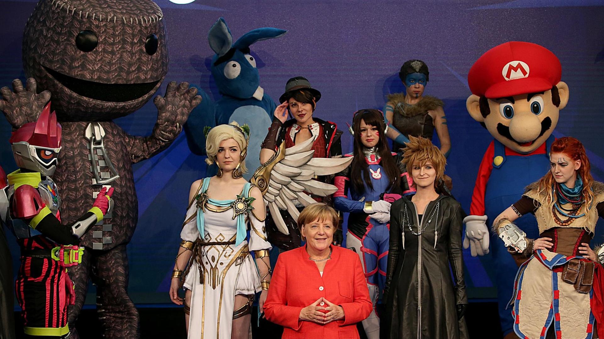 Bundeskanzlerin Angela Merkel (M, CDU) steht am 22.08.2017 in Köln (Nordrhein-Westfalen) unter Cosplayern.