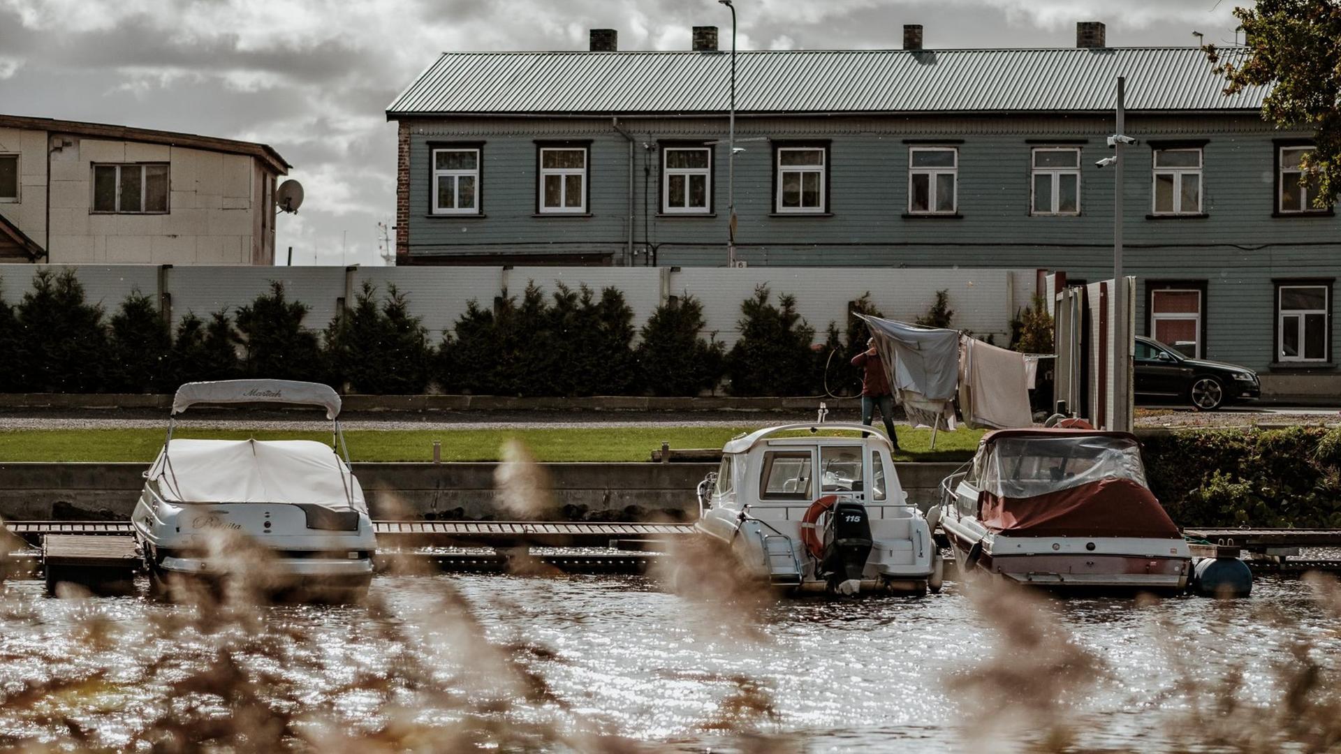 Herbstliche Ansicht aus dem estnischen Ferienort Pärnu: Hauser, Motorboote und eine Limousine