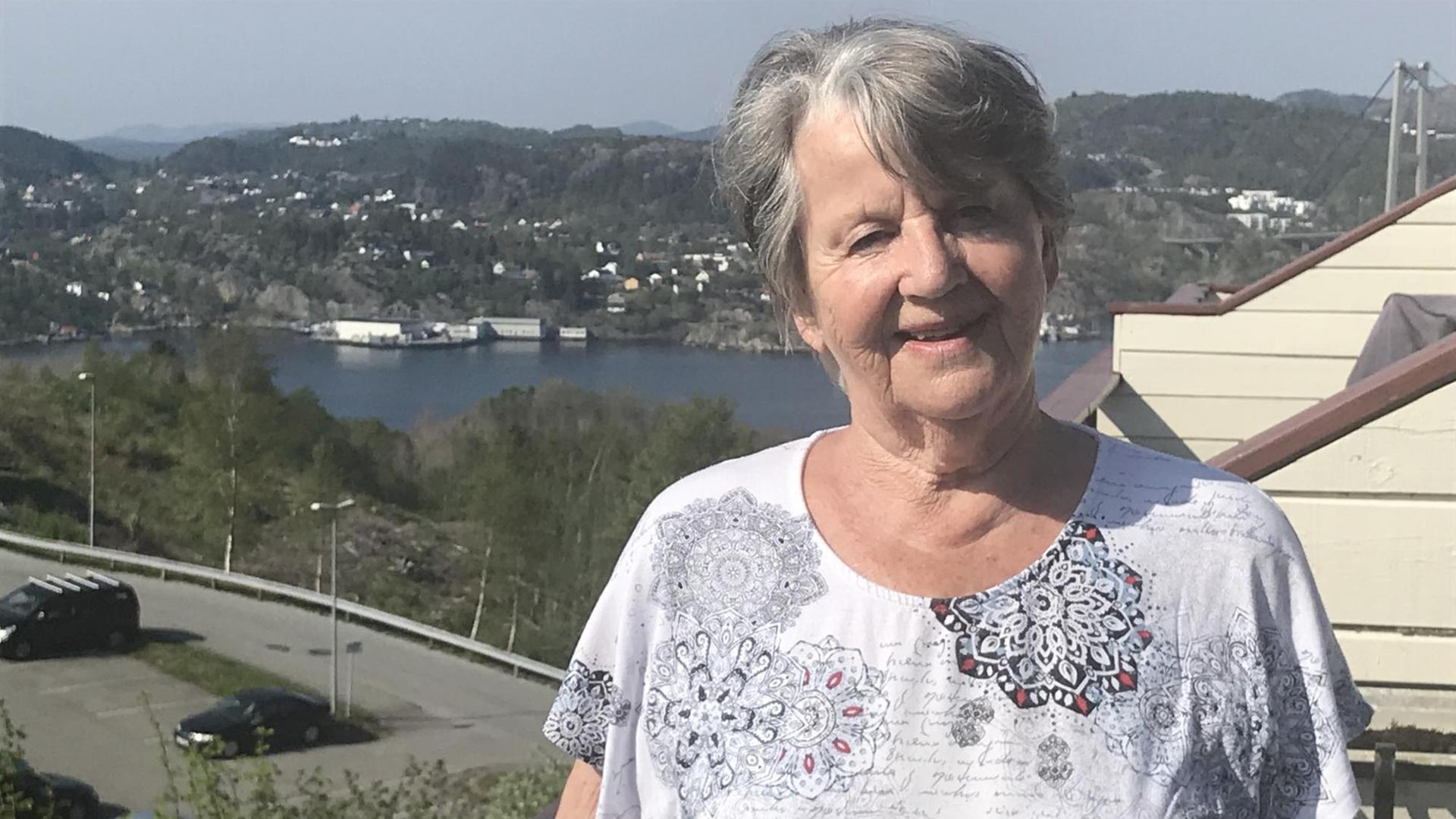 Die Norwegerin Elna Johnsen steht draußen vor ihrem Haus, das eine halbe Stunde von Bergen entfernt liegt