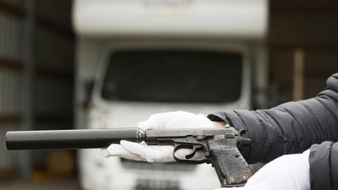 Ein Mitarbeiter des Bundeskriminalamtes hält eine Waffe