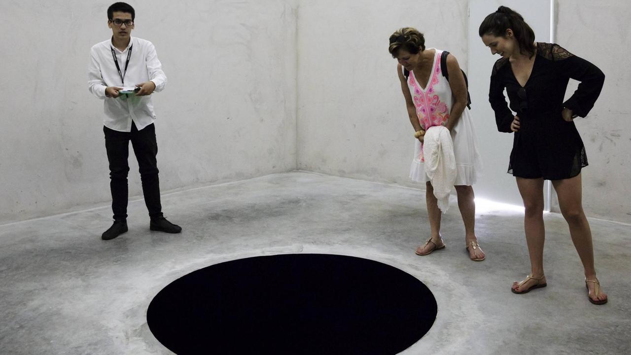 Museumsbesucher betrachten die Installation "Descent into Limbo" von Anish Kapoor in der Fundação de Serralves in Porto.