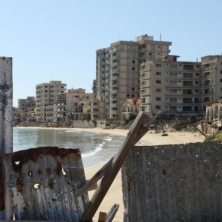 Ein Schild mit der Aufschrift "Verbotene Zone" vor einer Absperrung am Strand, dahinter sind die verfallenen Hotels des ehemaligen Touristenviertels Varosha in Famagusta zu sehen