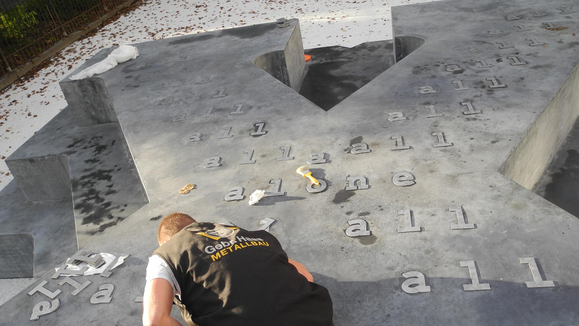 Ein Handwerker mit abschließenden Arbeiten am Denkmal für die Opfer des NS-Militärjustiz in Wien.