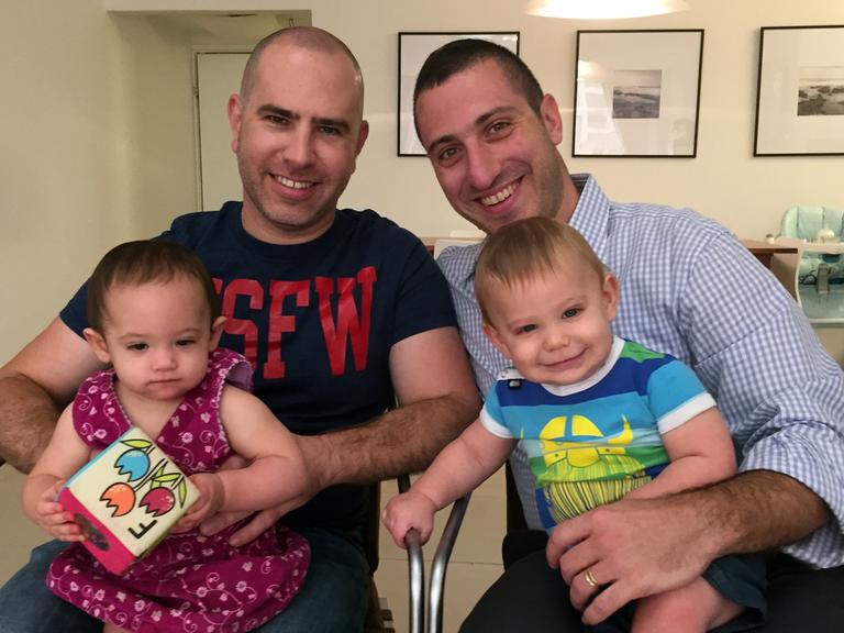 Lior Shohat (l) und Yehoshua Gurtler (r) haben in ihrer Wohnung in Tel Aviv, Israel, ihre Kinder Noa (v.l) und Juval auf dem Schoß. Gurtler ist religiöser Jude und schwul.