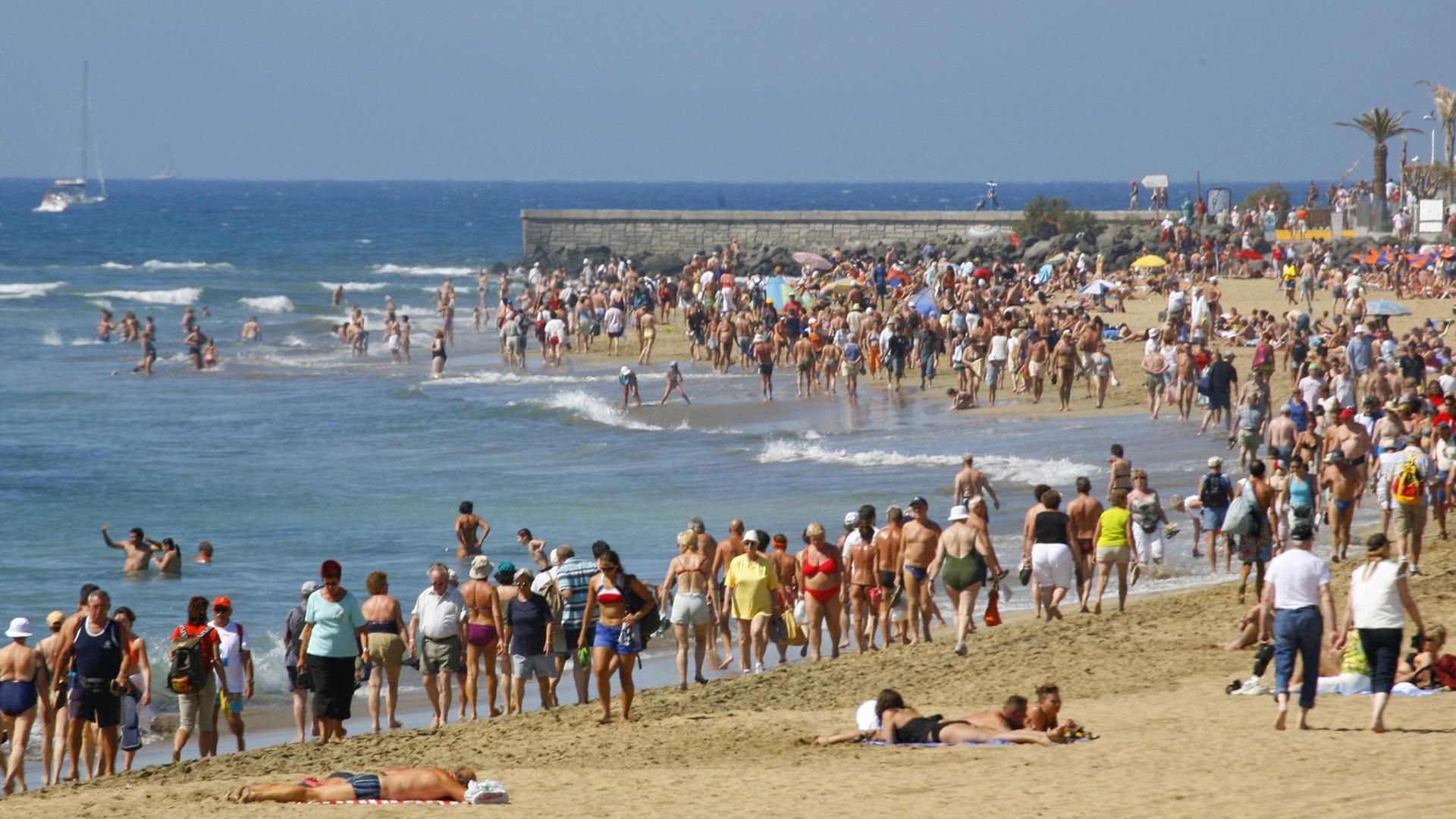 Touristen am Strand von Maspalomas auf der spanischen Insel Gran Canaria