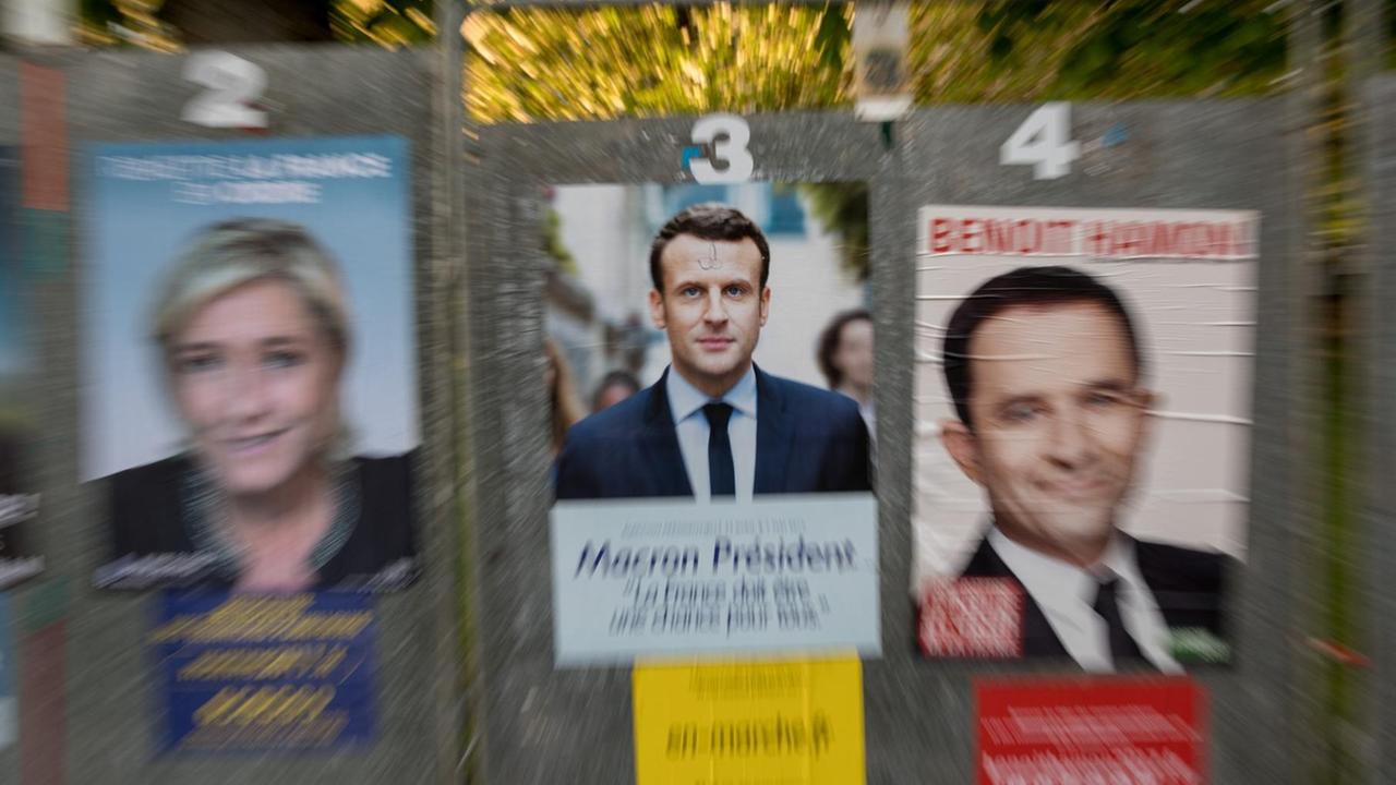 Wahlplakate mit den Spitzenkandidaten für die Präsidentschaftswahl in Frankreich, der Rechtspopulistin Le Pen (l) und dem sozialliberalen E. Macron (M), sind am 23.04.2017 in Henin-Beaumont zu sehen. 