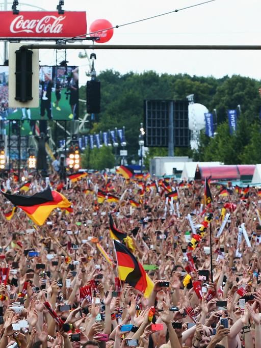 Bastian Schweinsteiger feiert mit Fans vor dem Brandenburger Tor in Berlin den Gewinn der Fußball-WM.