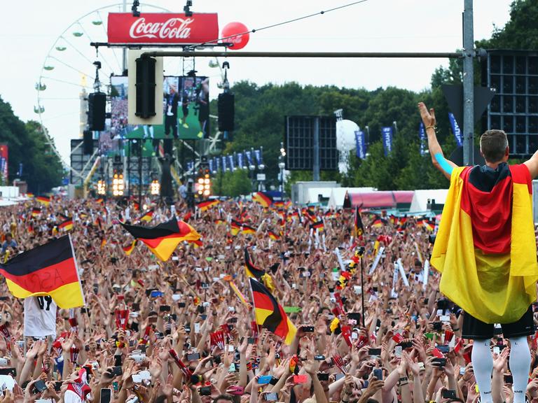 Bastian Schweinsteiger feiert mit Fans vor dem Brandenburger Tor in Berlin den Gewinn der Fußball-WM.