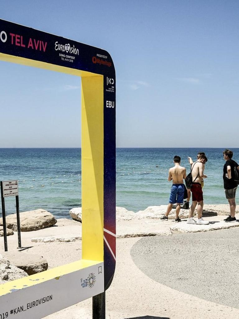 Touristen stehen mit Blick auf das Mittelmeer neben einem Werbeschild für den Eurovision Song Contest 2019. Vom 14. bis 18. Mai 2019 veranstaltet die Küstenstadt den internationalen Gesangswettbewerb Eurovision Song Contest (ESC) Touristen stehen mit Blick auf das Mittelmeer neben einem Werbeschild für den Eurovision Song Contest 2019. Vom 14. bis 18. Mai 2019 veranstaltet die Küstenstadt den internationalen Gesangswettbewerb Eurovision Song Contest (ESC)