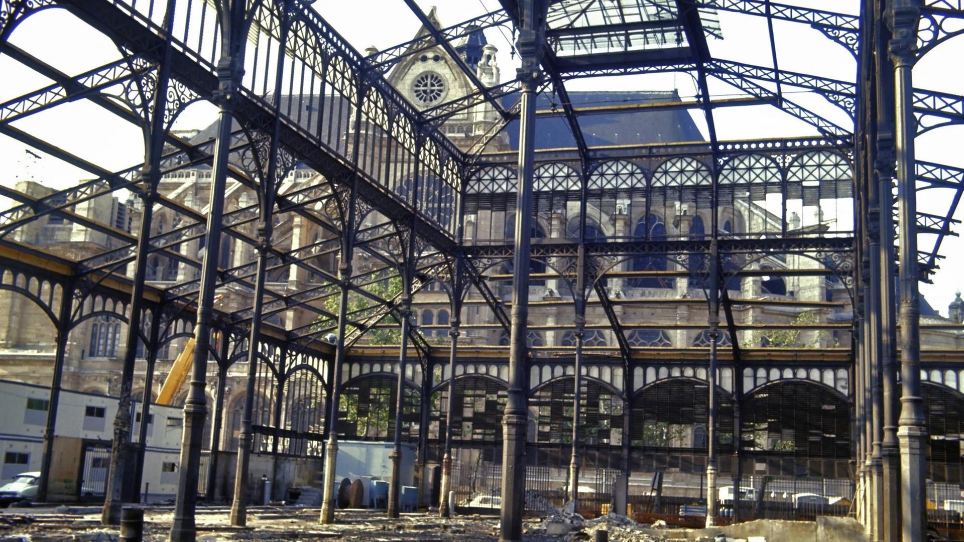 Teilansicht vom Innenren der halb abgerissenen Stahlbauten der alten Markthallen in Paris. Im Hintergrund die Kirche Saint-Eustache