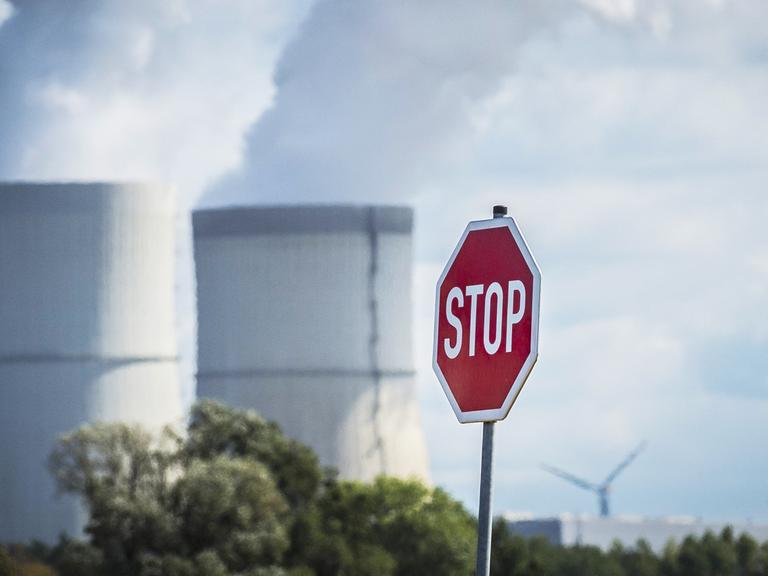Ein Stopschild, aufgenommen zwischen Windrädern und dem Kohlekraftwerk in Schwarze Pumpe