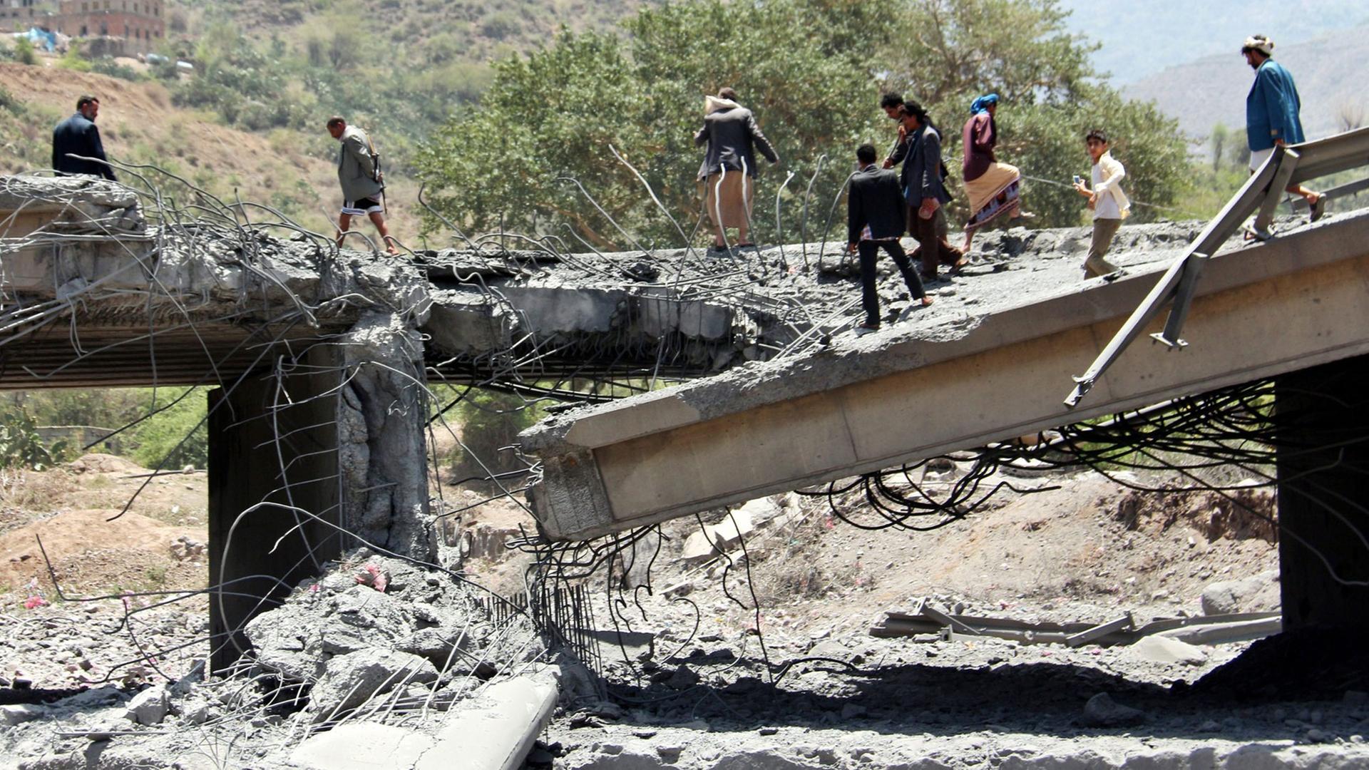 Yemenis stand on a bridge allegedly hit by an airstrike carried out by the Saudi-led coalition near the central city of Ibb, Yemen, 21 April 2015.