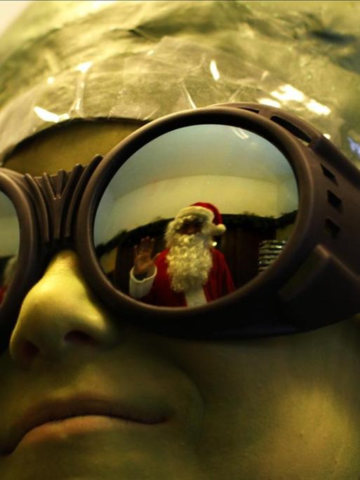 Der Weihnachtsmann spiegelte sich in der Brille einer Person, die aussieht wie ein Ausserirdischer.