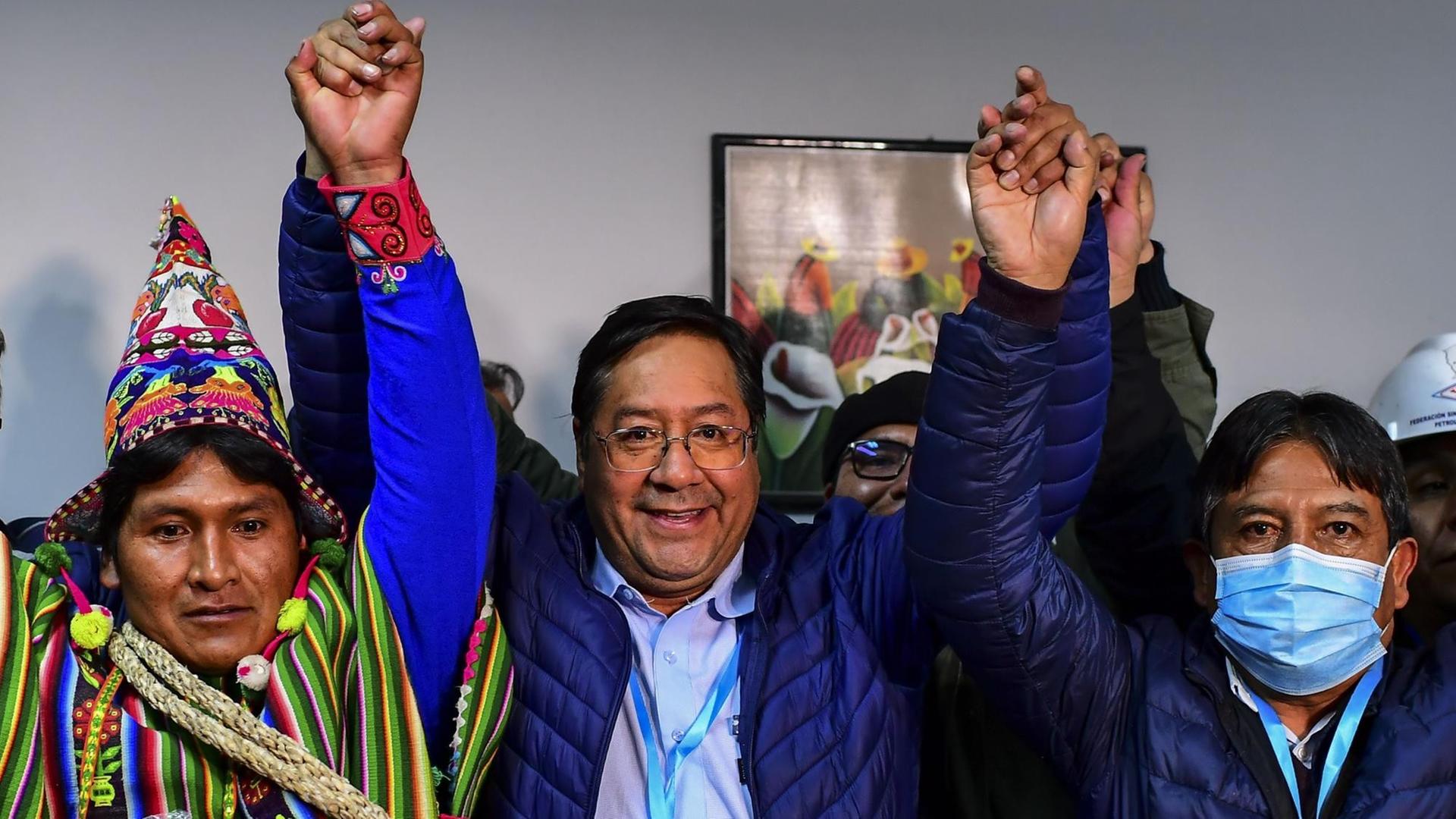 Der neue Präsident von Bolivien Luis Arce hebt die Arme und jubelt.