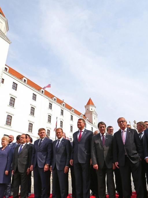 Die EU-Staats- und Regierungschefs stehen in mehreren Reihen auf einem roten Teppich zum Gruppenfoto bereit, im Hintergrund die Burg von Bratislava
