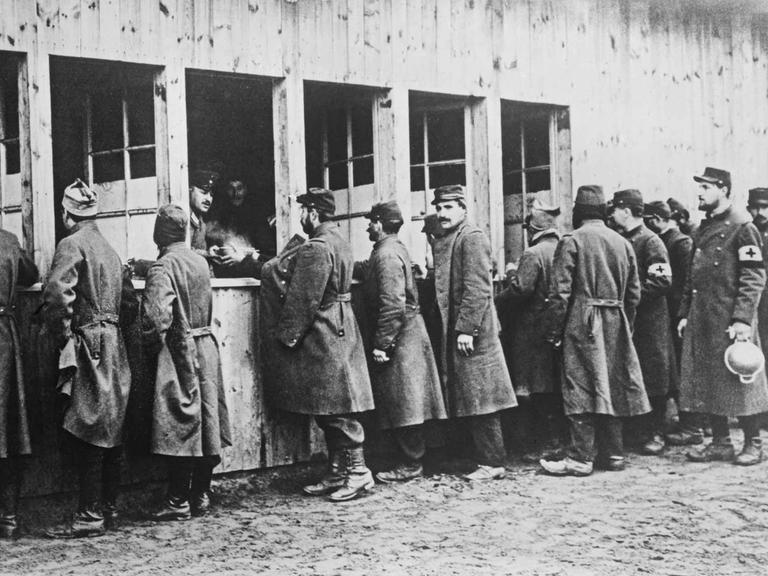 Kriegsgefangene im Ersten Weltkrieg stehen Schlange für ihre Essensrationen.